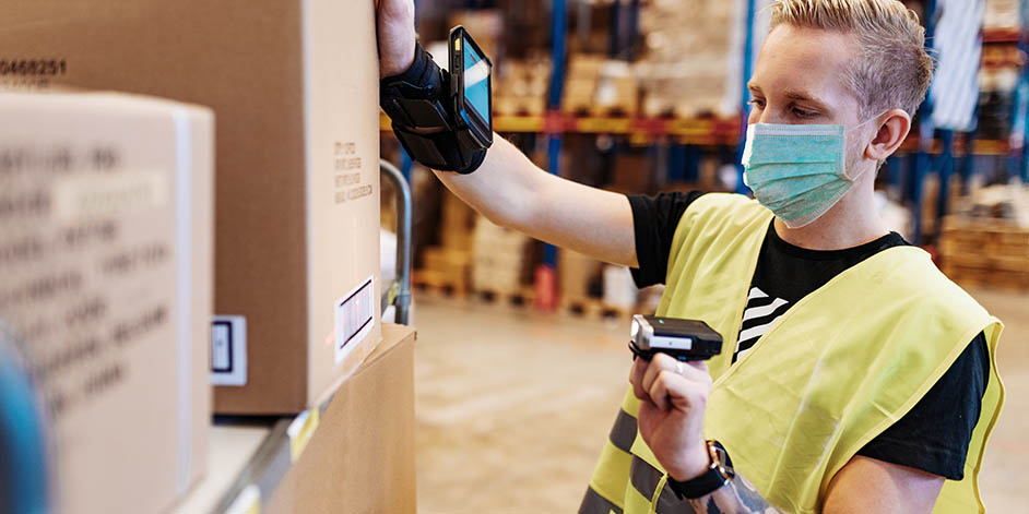 a man wearing a face mask working at a warehouse